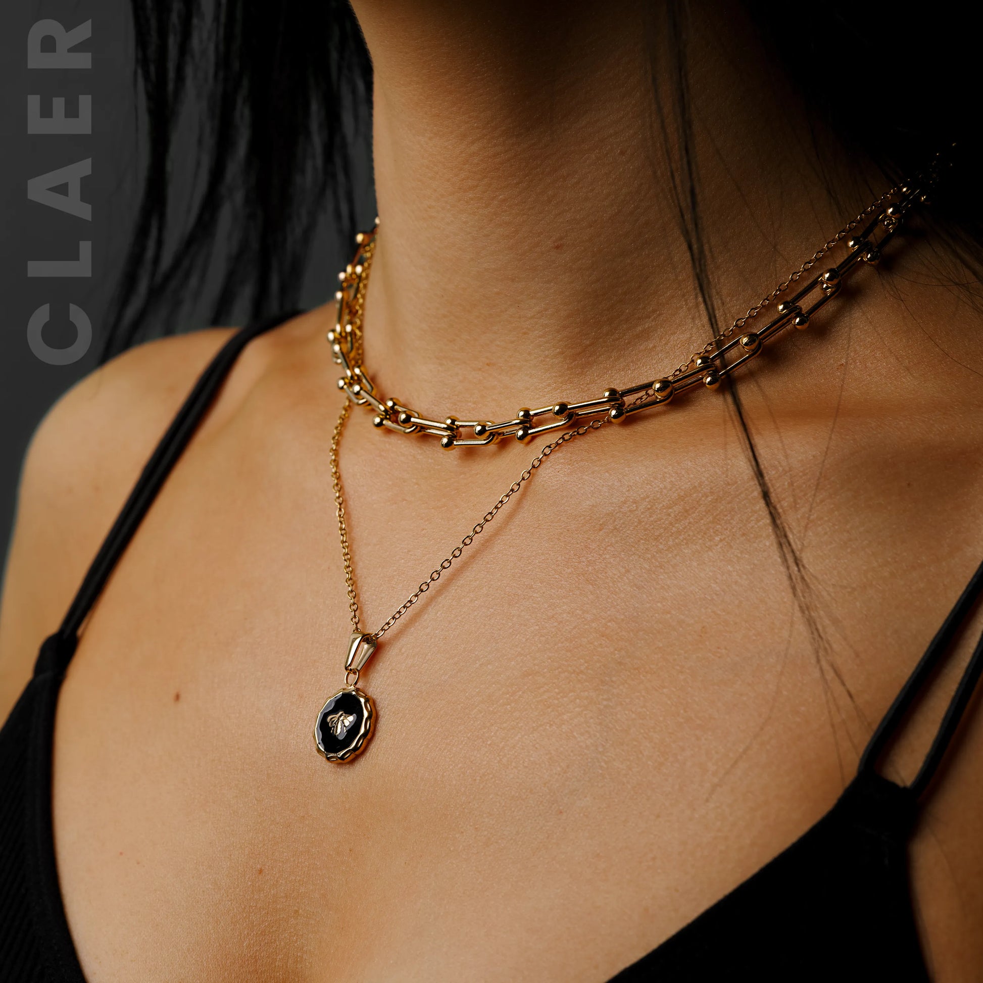 Goldene Horseshoe-Halskette mit einer Bienen-Charm-Kette, getragen.