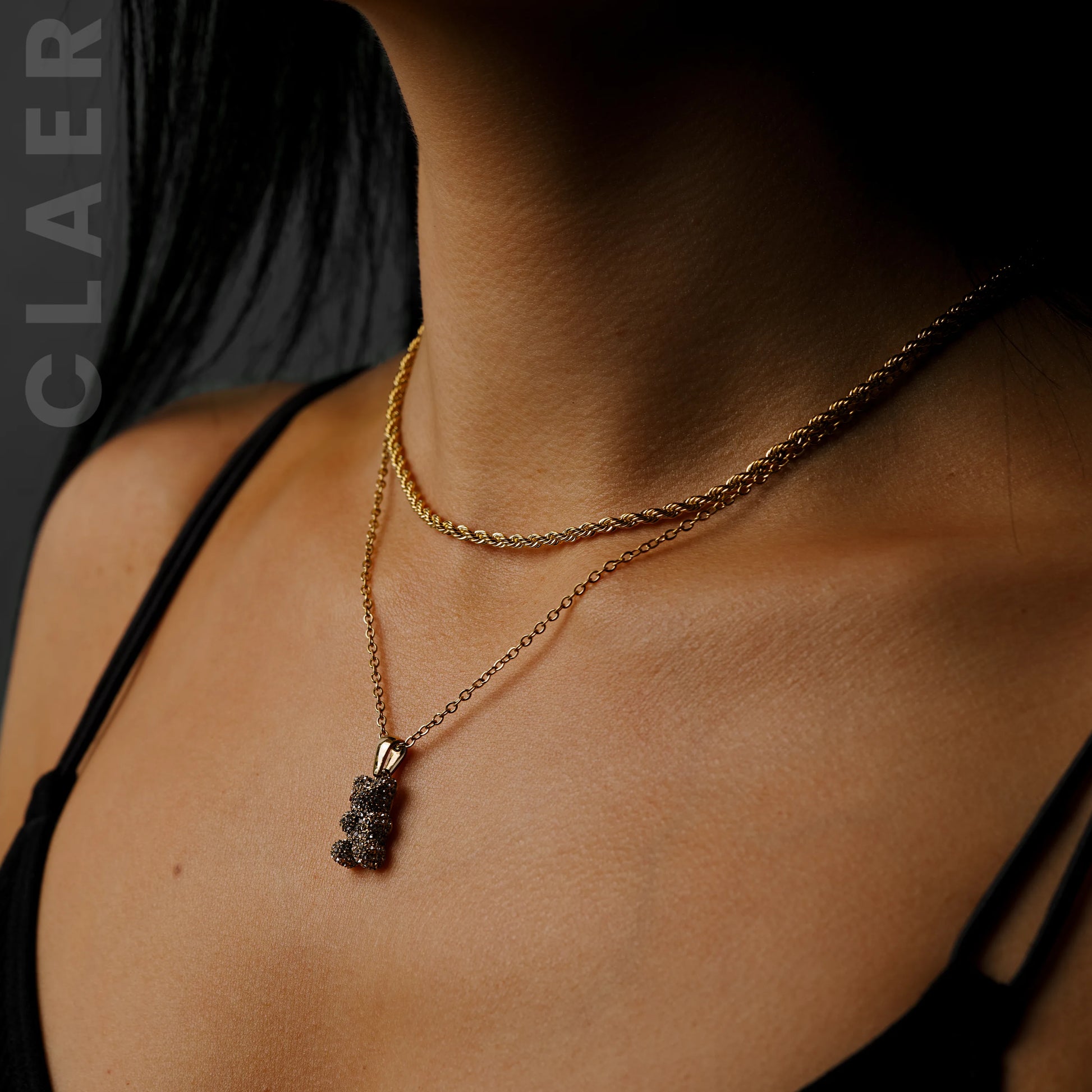 Goldene Rope-Kette und Gliederkette mit einem Diamantbär-Anhänger, getragen.