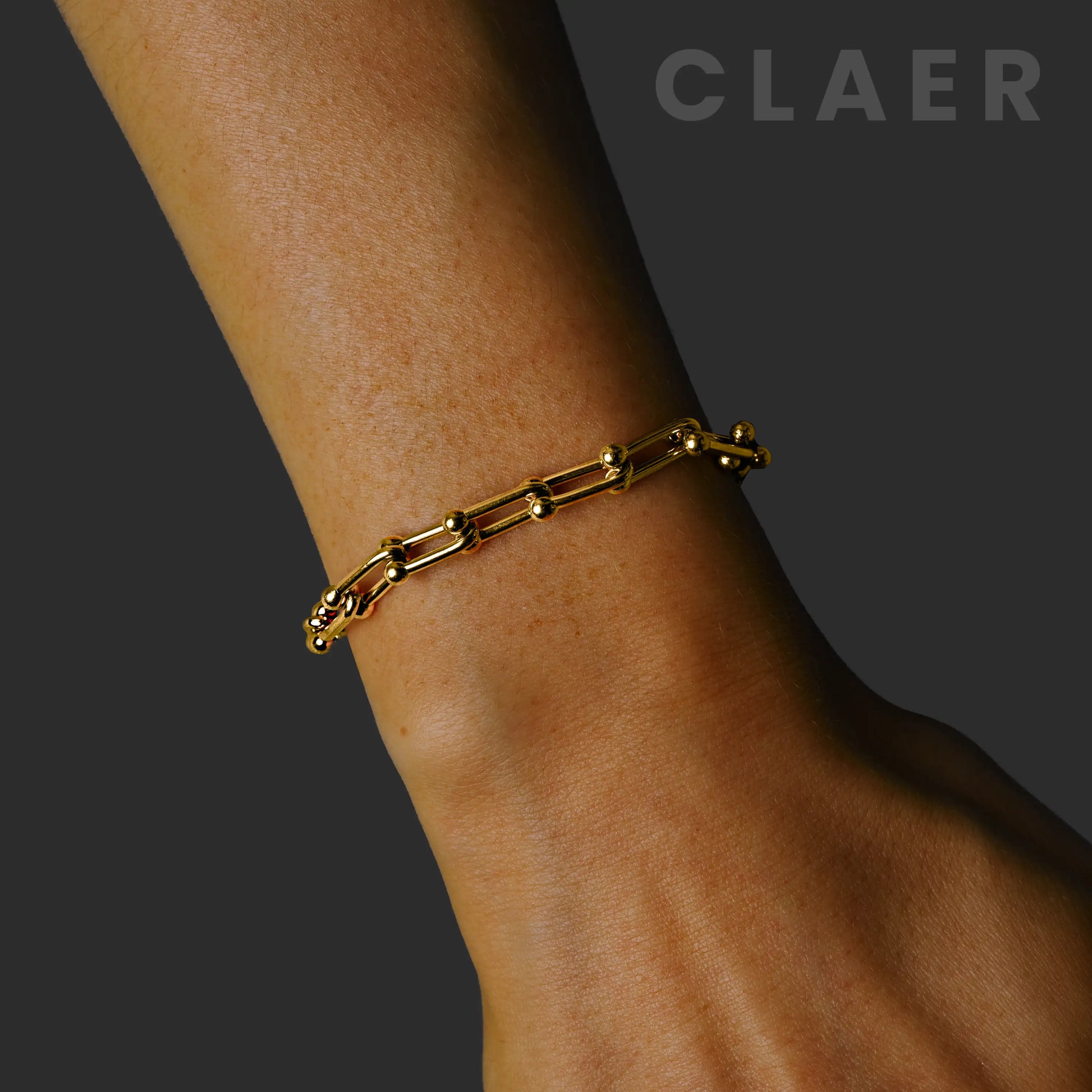 Goldenes Horseshoe-Armband, getragen am Handgelenk.