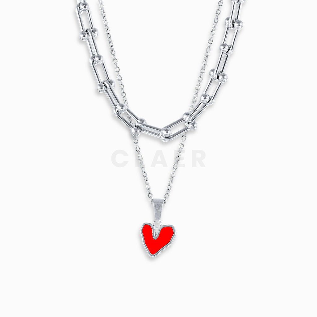 Silberne Horseshoe-Gliederkette mit unregelmässigem Herzanhänger.
