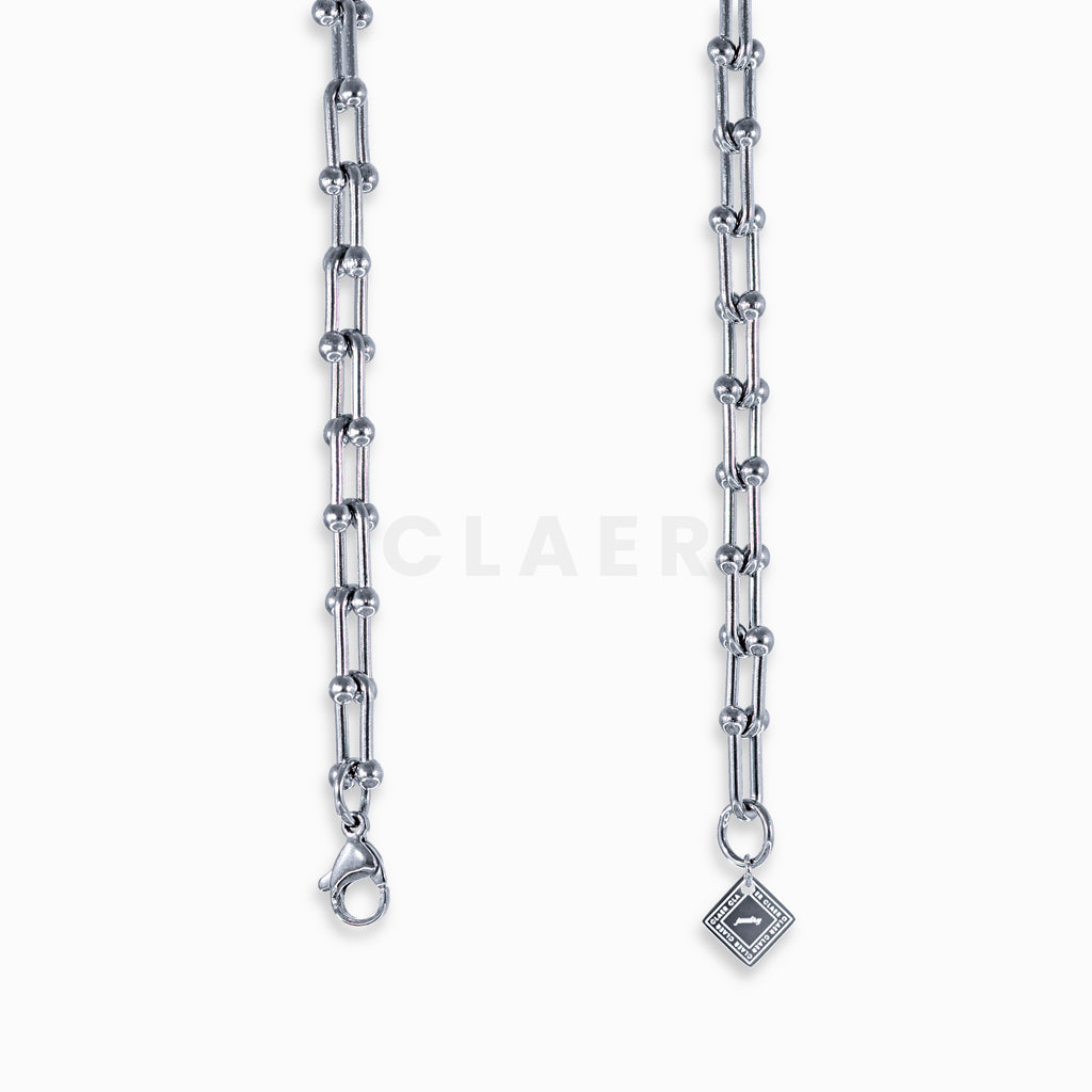 Silberne Horseshoe-Halskette mit Detailansicht des Verschlusses und Logo-Tag von CLAER.