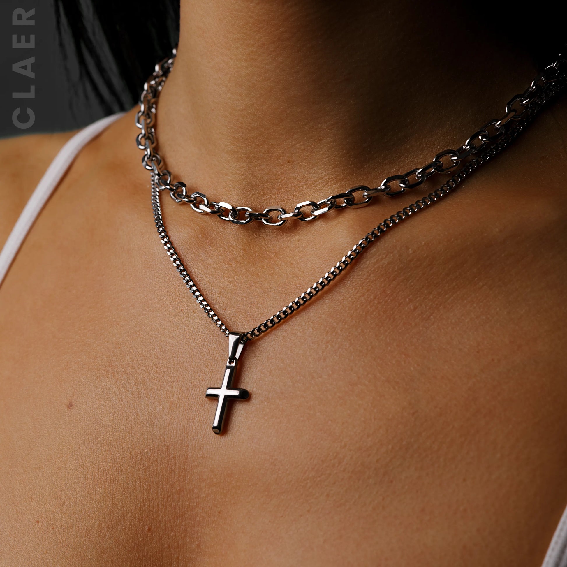 Silberne geschliffene Link-Kette und Gliederkette mit einem Mini-Kreuzanhänger, getragen.
