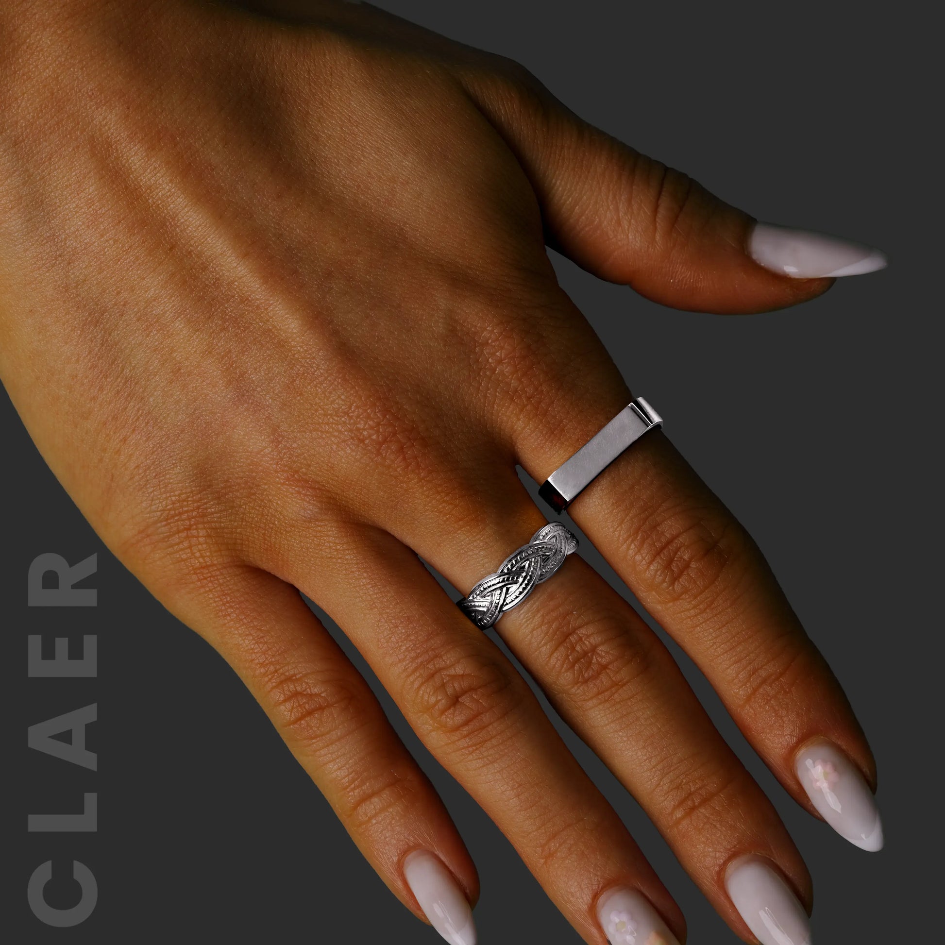 Silberner Ring mit Spiegeloptik und ein offener Ring mit zopfartigem Design.
